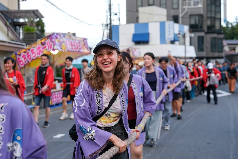 地域の祭りに参加して文化を体験する外国人モニター